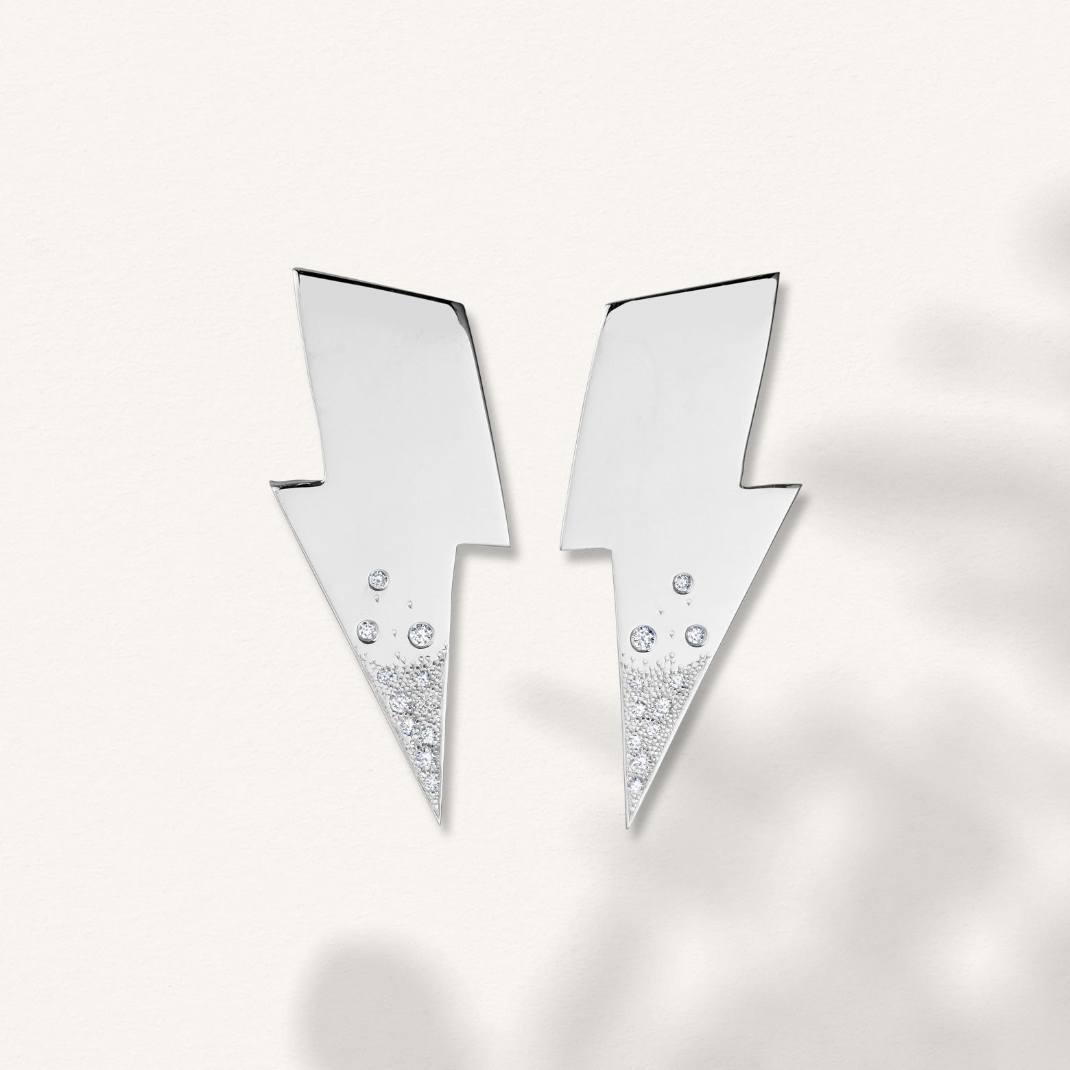 Kelly Woodcroft handcrafted lightening bolt shaped earrings in sterling silver feature a spattering of small diamonds.
