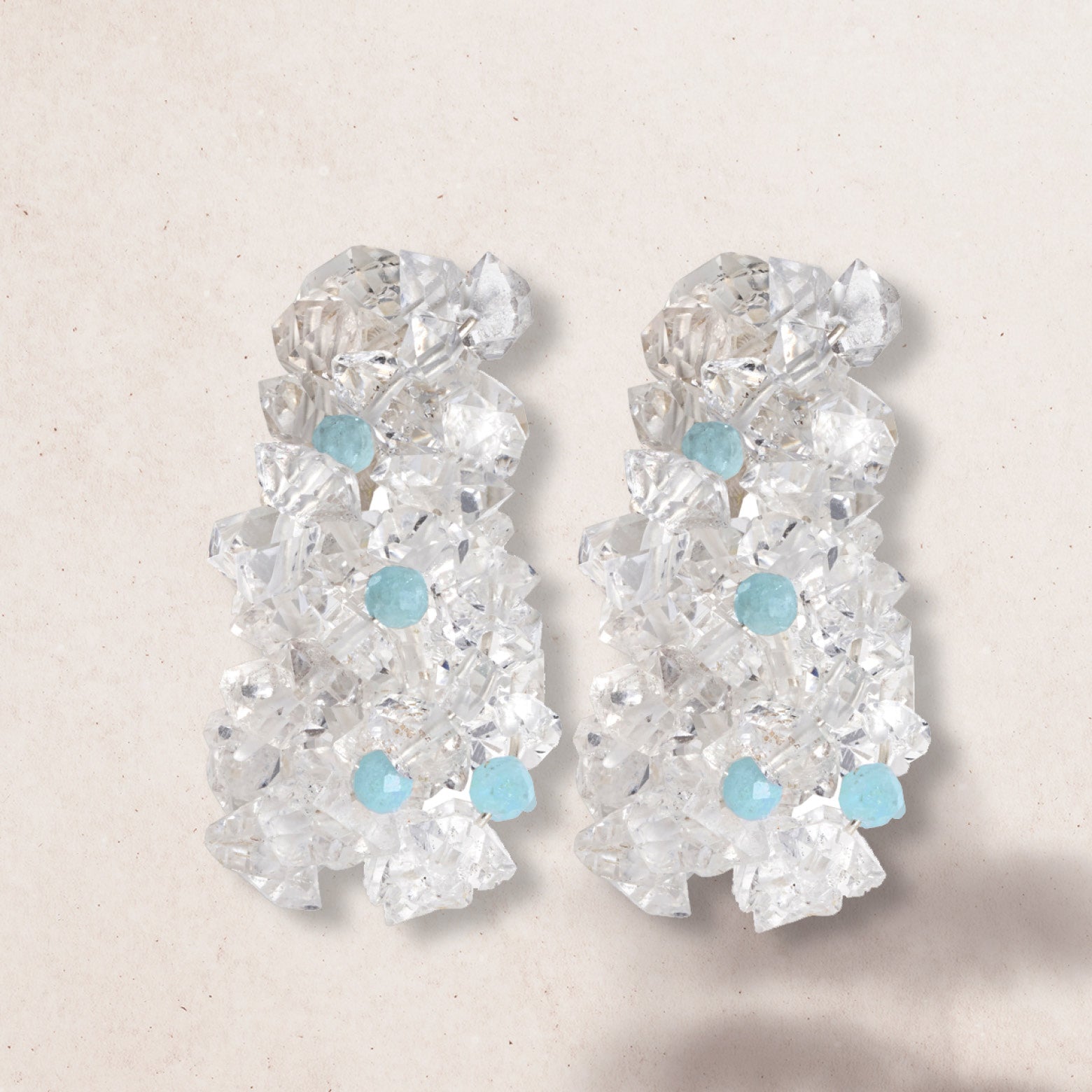 Flat lay of cluster drop earrings of aquamarine and herkimer diamonds