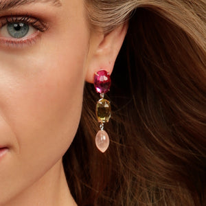 A close up of the Kelly Woodcroft mermaid earrings that feature a pink, yellow and light pink stone dangles.