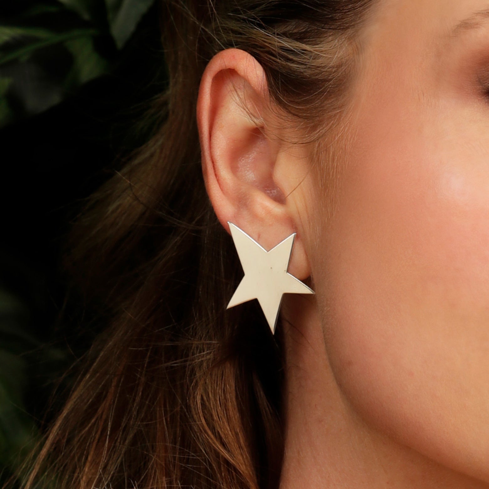 Close up of an ear wearing the Kelly Woodcroft silver starfish earrings.