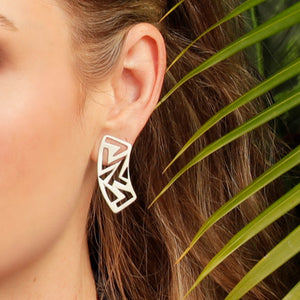 A close up of an ear wearing Kelly Woodcroft silver treetop canopy earrings.